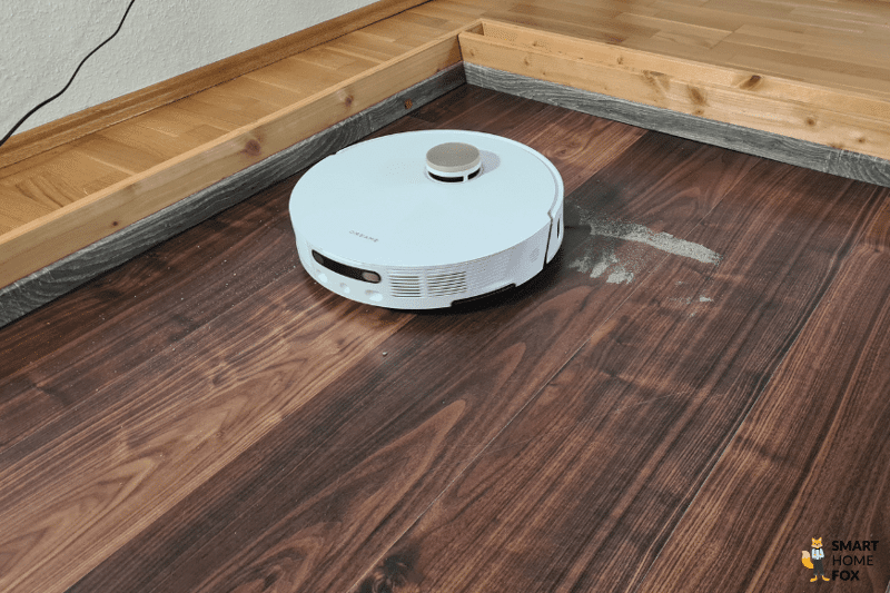 Der Dreame L20 Ultra saugt im Test Sand auf einen Laminatboden.